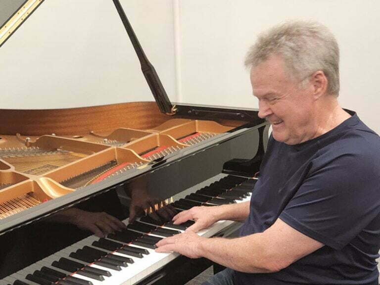 Bob Perry laughing at piano - Prestige Piano Services